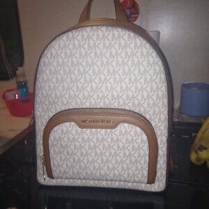 Micheal kors backpack bag with 2 big openings and one small pouch in the front.